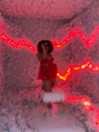 a woman standing in a room with red lights